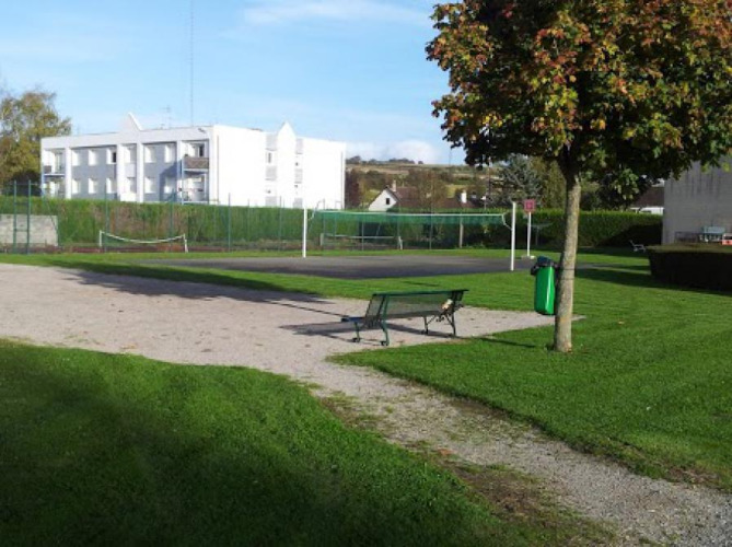 Buitenruimte bij Camping Seasonova Les Marguerites, Hauts-de-France, met bankje, gras en tennisbaan.