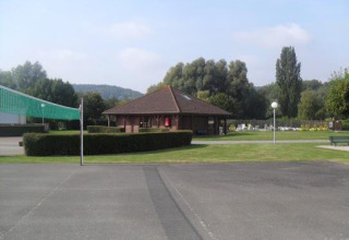 Billede af Camping Seasonova Les Marguerites feriepark i Hauts-de-France, Frankrig, med grønne områder og bygninger.