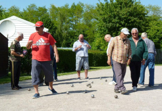 Un gruppo di uomini anziani gioca a pétanque all'aperto al Camping Seasonova Les Marguerites, Hauts-de-France.