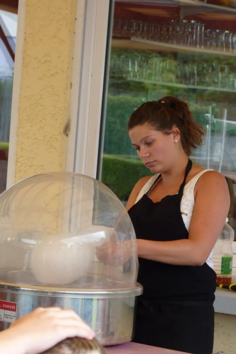 Mujer haciendo algodón de azúcar en una máquina en Camping Seasonova Les Marguerites, Hauts-de-France, Francia.