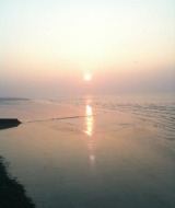 Atardecer tranquilo sobre aguas calmadas cerca de Gamaches, Hauts-de-France, Francia, con un cielo pastel.