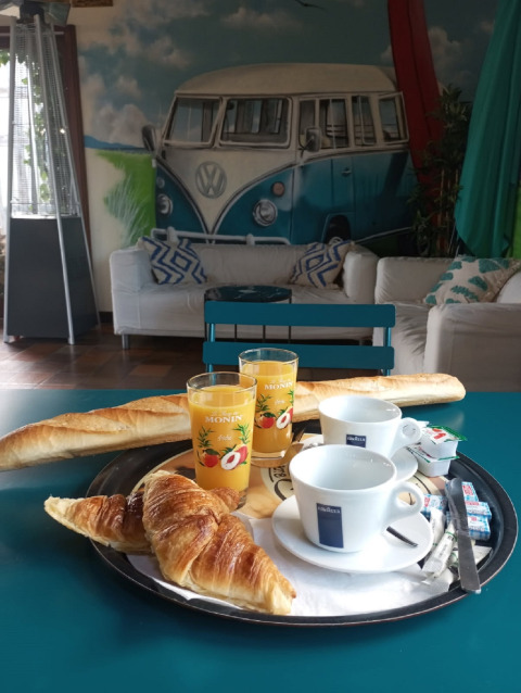 Desayuno francés con croissants, baguette, zumo y café en mesa de Cottage Prestige, Etennemare, Francia.