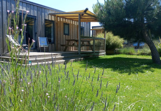 Cottage Prestige verblijf bij Camping Seasonova Etennemare in Frankrijk, met houten terras en gazon.