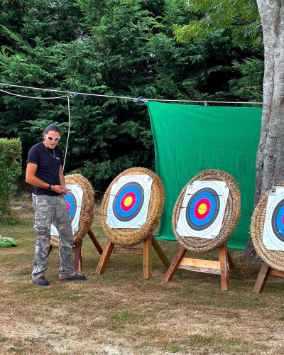 Persona junto a dianas de tiro con arco en el exterior de Ecolodge Junior, Camping Seasonova Etennemare, Francia.