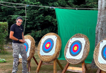 Persona junto a dianas de tiro con arco en el exterior de Ecolodge Junior, Camping Seasonova Etennemare, Francia.