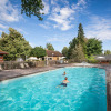 Outdoor swimming pool with children, sun loungers and umbrellas at Camping de l'Ill - Colmar, Grand Est, France.