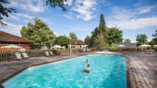 Buitenzwembad met kinderen, ligstoelen en parasols op Camping de l'Ill - Colmar in Grand Est, Frankrijk.