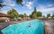 Udendørs swimmingpool med børn, liggestole og parasoller på Camping de l'Ill - Colmar i Grand Est, Frankrig.