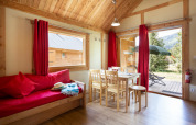 Vista interior de Chalet Montana en Camping de l'Ill - Colmar, con muebles de madera y acceso al jardín.