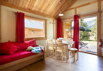 Vista interna dello Chalet Montana al Camping de l'Ill - Colmar, con arredi in legno e accesso al giardino.