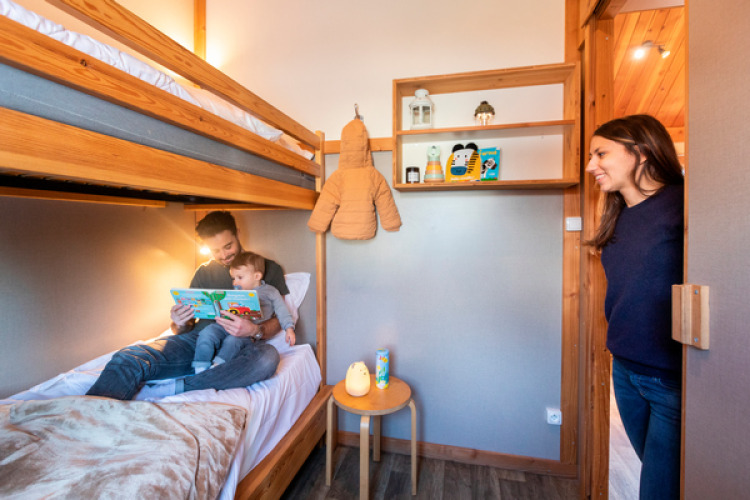 Una familia disfruta de una habitación con literas en el Chalet Montana de Camping de l'Ill - Colmar en Francia.
