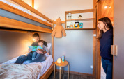 Una familia disfruta de una habitación con literas en el Chalet Montana de Camping de l'Ill - Colmar en Francia.