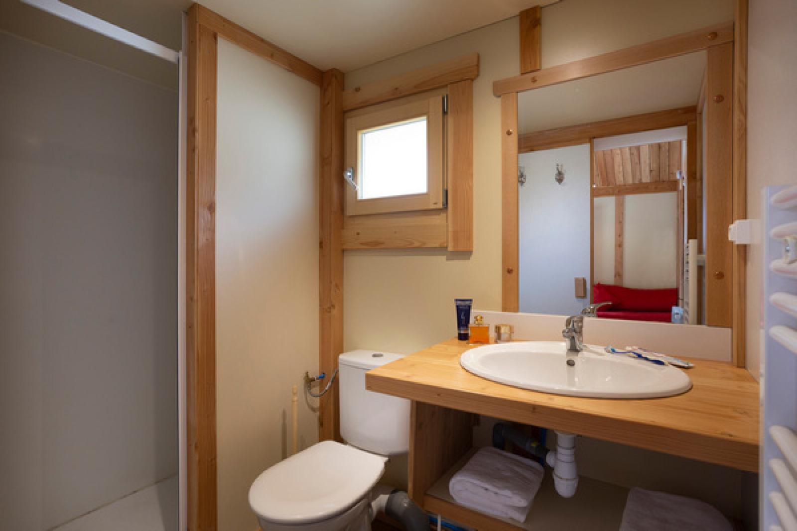 Moderne badkamer met houten accenten, spiegel, wastafel, toilet en douche in Chalet Montana, Colmar.
