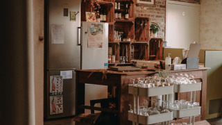 Acogedora cocina en Feather Down Hoeve den Overdraght con estanterías de madera y vasos en Bélgica.