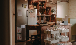 Acogedora cocina en Feather Down Hoeve den Overdraght con estanterías de madera y vasos en Bélgica.