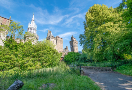 Antiguo castillo rodeado de naturaleza y árboles cerca de Bala, Gales, bajo un cielo azul despejado.