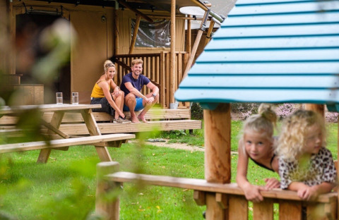Gezin geniet bij de GlampCamp Safari Tent op Camping De Klimberg in Nederland, kinderen spelen buiten.