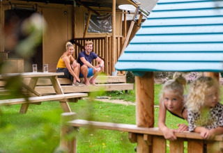 Gezin geniet bij de GlampCamp Safari Tent op Camping De Klimberg in Nederland, kinderen spelen buiten.