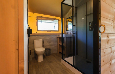 Badeværelse i GlampCamp Safari Tent på Camping De Klimberg, Nederlandene, med bruser og toilet.