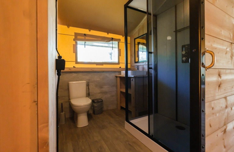 Baño en GlampCamp Safari Tent en Camping De Klimberg, Países Bajos, con ducha y sanitario moderno.