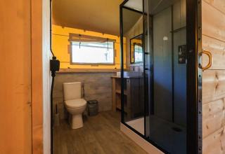 Badkamer in GlampCamp Safari Tent bij Camping De Klimberg, Nederland, met douche en toilet.