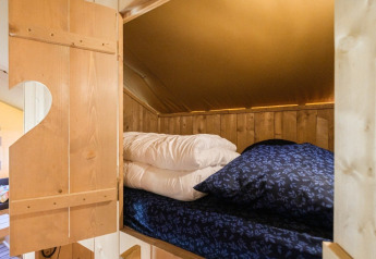 Innenansicht eines gemütlichen Bettes im GlampCamp Safari Tent auf Camping De Klimberg, Niederlande.