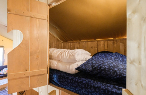 Innenansicht eines gemütlichen Bettes im GlampCamp Safari Tent auf Camping De Klimberg, Niederlande.