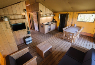 Indre af et GlampCamp Safari-telt på Camping De Klimberg, Nederlandene, med træmøbler og køkken.