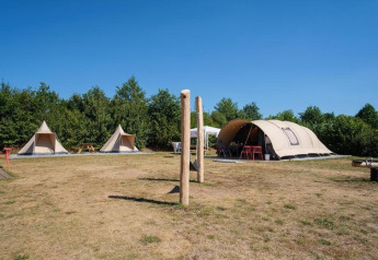 Tende safari e tenda tunnel De Waard al Camping De Klimberg nei Paesi Bassi in una giornata soleggiata.