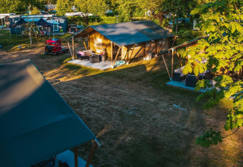 Vista di una tenda safari al Recreatiepark De Achterste Hoef nei Paesi Bassi, circondata dal verde.