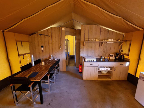 Interior de una tienda safari en Recreatiepark De Achterste Hoef, Países Bajos, con zona de comedor y cocina