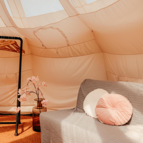 Indretning af Lotus Belle safari-telt på Recreatiepark De Achterste Hoef, med sofa og dekoration.