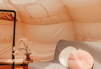 Interieur van de Lotus Belle safaritent op Recreatiepark De Achterste Hoef met bank en decoratie.