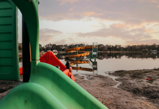 Vista de toboganes y botes de remo junto al lago en la cabaña Klapkot, Recreatiepark De Achterste Hoef, Países Bajos.