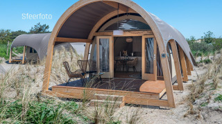 Moderne Waterlodge ved Recreatiepark De Achterste Hoef, Nederlandene, omgivet af sand og klitter.
