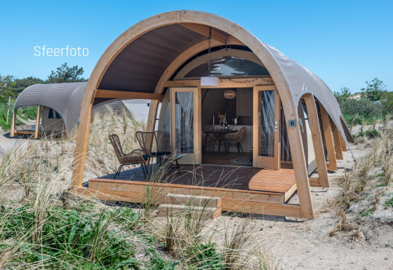 Moderna Waterlodge en Recreatiepark De Achterste Hoef, Países Bajos, rodeada de dunas de arena y vegetación.