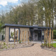 Lodge moderne Zypendaal Comfort à Veluwepark de Bosgraaf, Pays-Bas, entouré de forêt et d’un jardin.