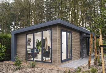 Moderna cabaña Zypendaal Comfort en Veluwepark de Bosgraaf, Países Bajos, rodeada de naturaleza y árboles.