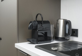 Kaffemaskine og elkedel på en bordplade i Zypendaal Comfort-lodge, Veluwepark de Bosgraaf, Holland.