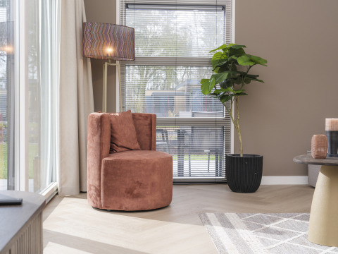 Rincón acogedor con silla redonda, lámpara de pie y planta en Batenburgh Deluxe, Veluwepark de Bosgraaf, Países Bajos.