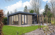 Moderne Zypendaal-Lodge im Veluwepark de Bosgraaf, Niederlande, mit Glasfront und Garten.