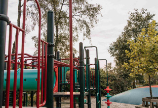 Parco giochi con struttura per arrampicata e scivolo sulla sabbia, tra alberi a De Achterste Hoef, Paesi Bassi.