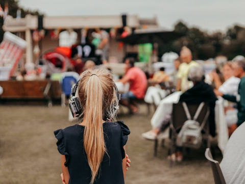 Una niña con auriculares disfruta de un evento al aire libre en Recreatiepark De Achterste Hoef, Brabante, Países Bajos.