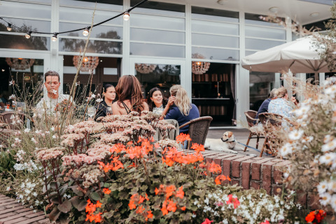 Des gens à une terrasse fleurie du Recreatiepark De Achterste Hoef, Brabant-Septentrional, Pays-Bas.