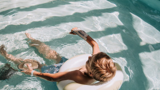 Niño relajándose en un flotador inflable en la piscina de Recreatiepark De Achterste Hoef, Países Bajos.