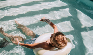 Niño relajándose en un flotador inflable en la piscina de Recreatiepark De Achterste Hoef, Países Bajos.