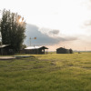 Cabins and green fields at Feather Down Botterheerd holiday park in Groningen, Netherlands, at sunset.