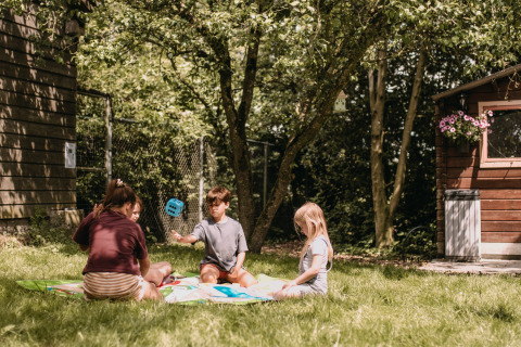 Kinder spielen im Freien auf dem Rasen im Ferienpark Feather Down Botterheerd in Groningen, Niederlande.
