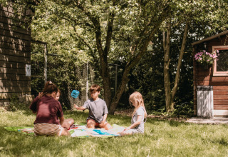 Børn leger udendørs på græs ved Feather Down Botterheerd feriepark i Groningen, Holland.