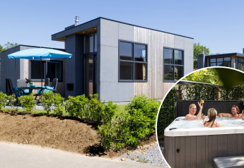Modern Z Module Wellness lodge at Résidence Valkenburg, Netherlands, featuring patio and family in hot tub.